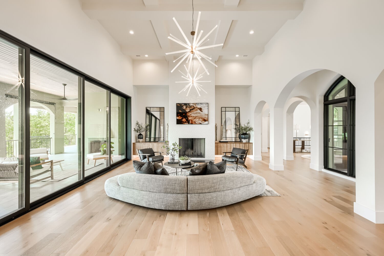 8132 Magnolia Ridge Cove Austin, TX 78738 - Photo 15 of 38 Architectural elegance defines this great room, featuring soaring ceilings, a stately fireplace, and expansive glass doors opening to a covered patio.
