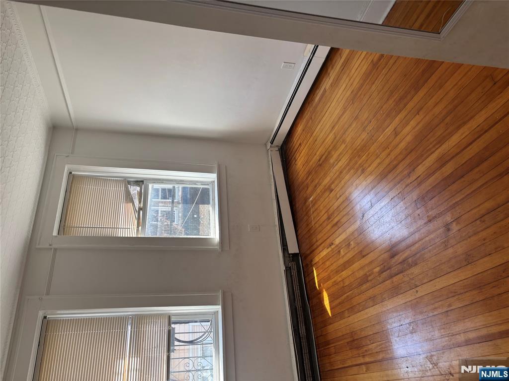 86 Center Street, Unit 2F Clifton, NJ 07011 - Photo 5 of 11 a view of empty room with wooden floor and fan