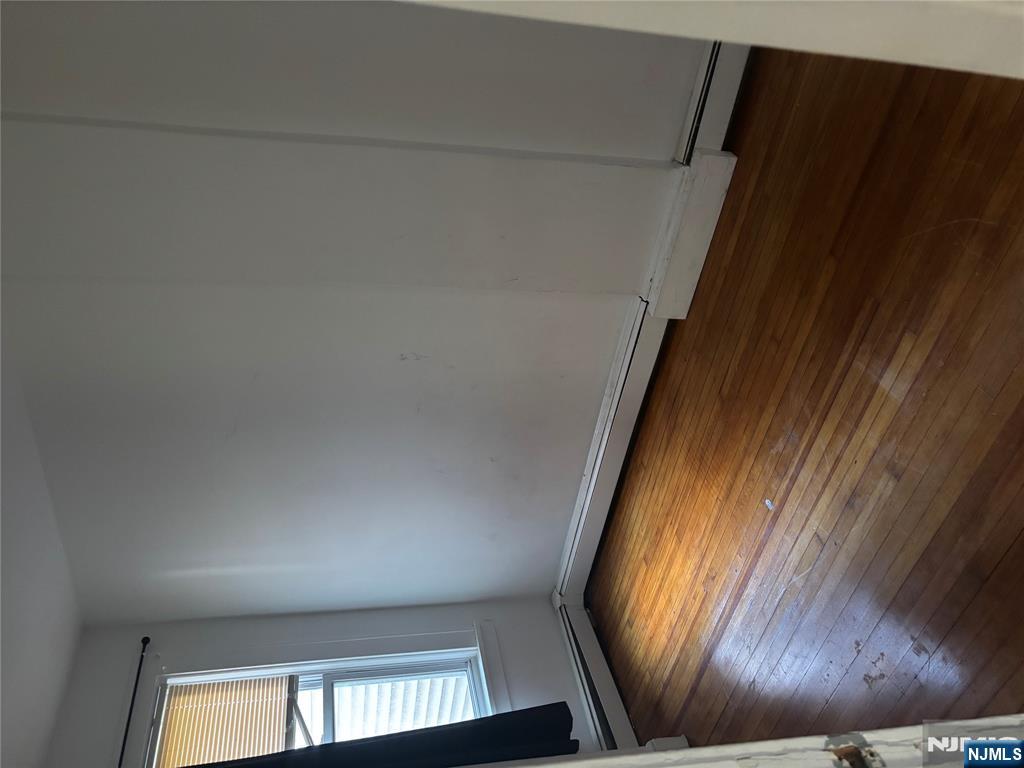 86 Center Street, Unit 2F Clifton, NJ 07011 - Photo 8 of 11 an empty room with wooden floor and windows