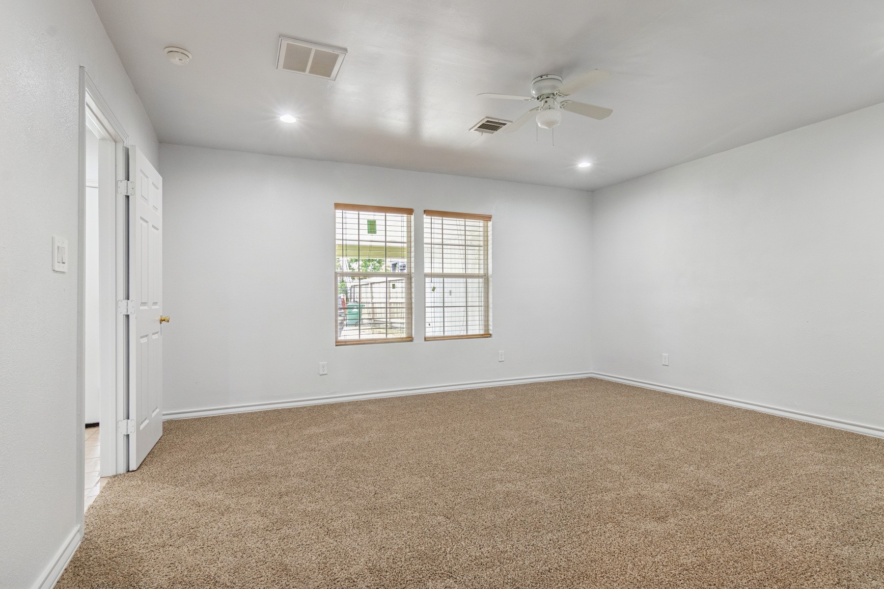 4505 Cochran Street Houston, TX 77009 - Photo 12 of 25 an empty room with a ceiling fan and window