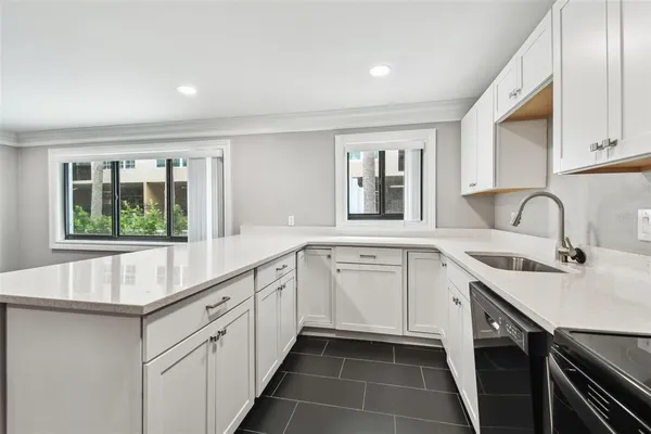 a kitchen with a sink dishwasher and a refrigerator