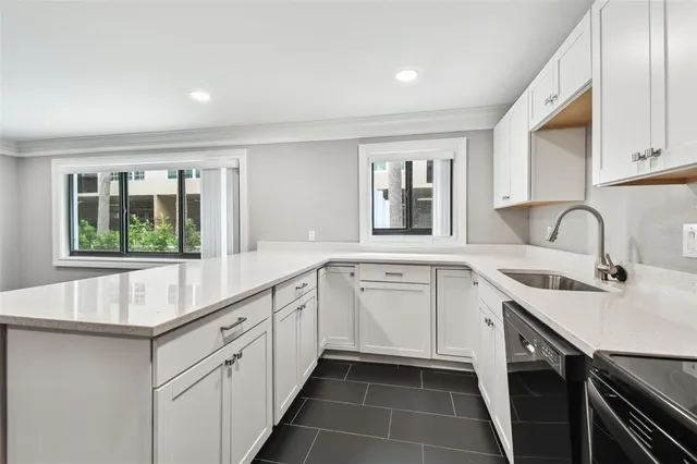 a kitchen with a sink dishwasher and a refrigerator