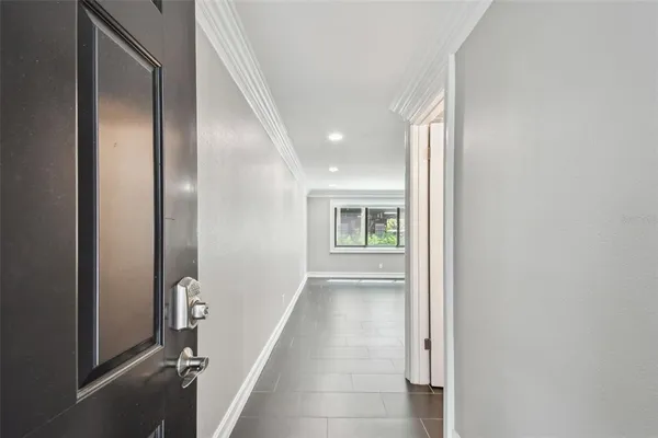 a large white kitchen with stainless steel appliances granite countertop a stove a sink a refrigerator and white cabinets with wooden floor