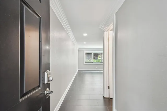 a large white kitchen with stainless steel appliances granite countertop a stove a sink a refrigerator and white cabinets with wooden floor