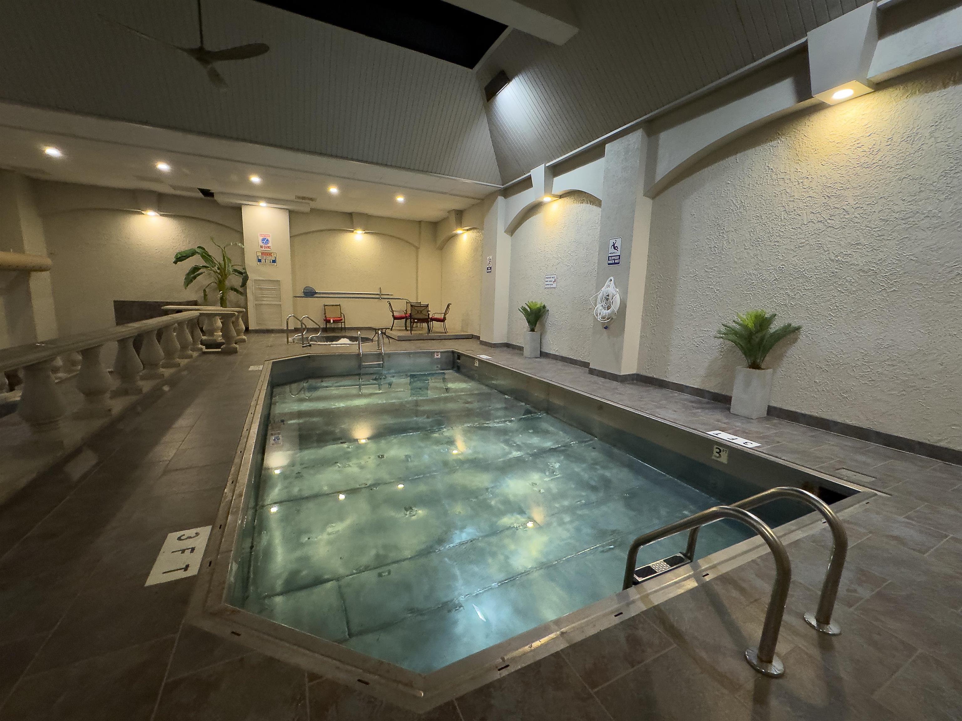 109 North Main Street, Unit 907 Memphis, TN 38103 - Photo 28 of 29 Indoor swimming pool featuring metal access ladders, surrounding tile flooring, and integrated wall lighting