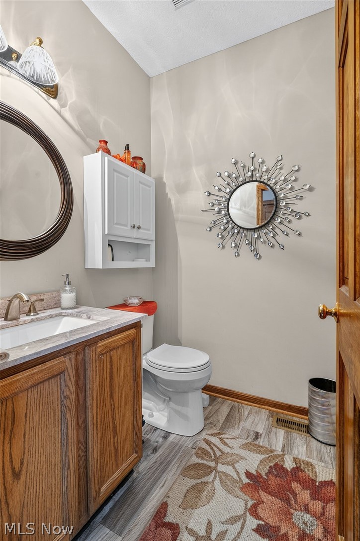 2601 Charing Cross Road Northwest Canton, OH 44708 - Photo 14 of 49 Elegant bathroom featuring warm wood-finish vanity cabinetry, marble-topped countertop, and chrome fixtures