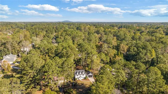 a living room with furniture wooden floor and a dining table