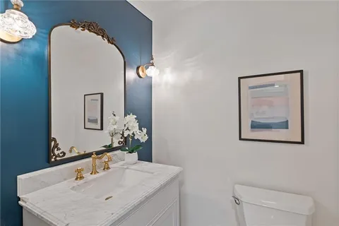 a kitchen with stainless steel appliances a stove a sink a refrigerator cabinets and a dining table with wooden floor