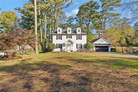a front view of a house with a garden and yard