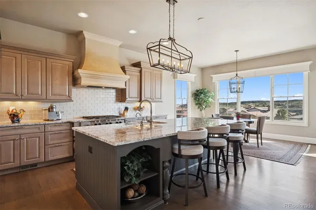 a kitchen with kitchen island granite countertop a sink a center island and cabinets