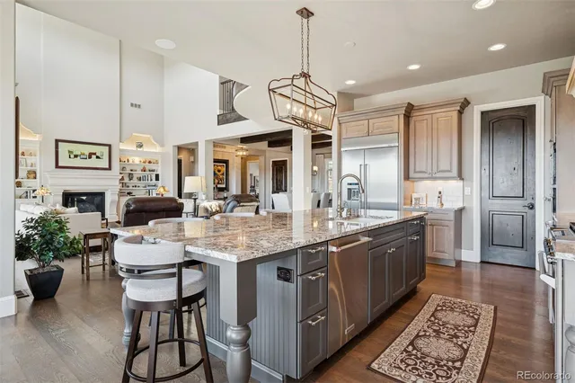 a large kitchen with stainless steel appliances kitchen island granite countertop a sink and cabinets