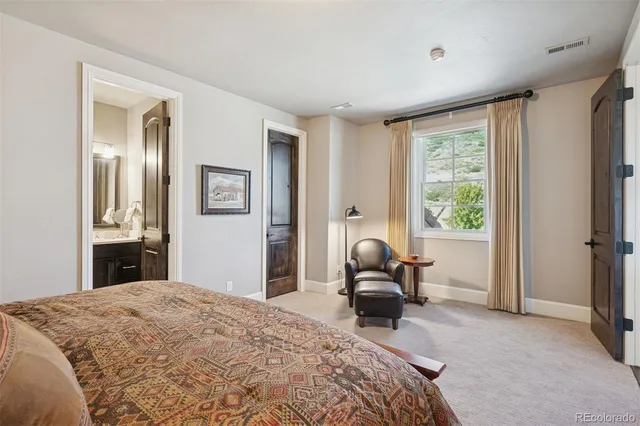 a bedroom with a bed and large windows