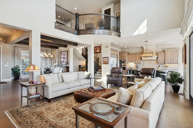 a living room with furniture kitchen view and a chandelier