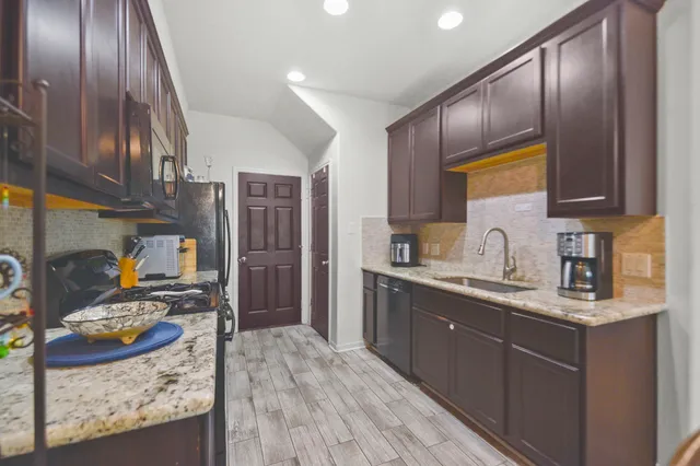 a kitchen with stainless steel appliances granite countertop a sink stove and refrigerator