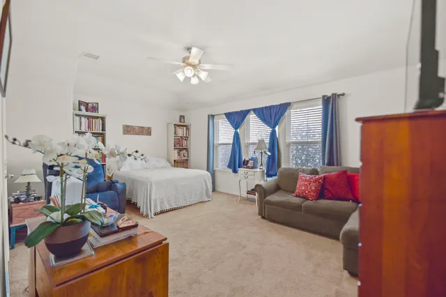 a bedroom with a bed chair and window