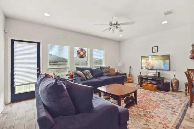 a living room with furniture a large window and a flat screen tv
