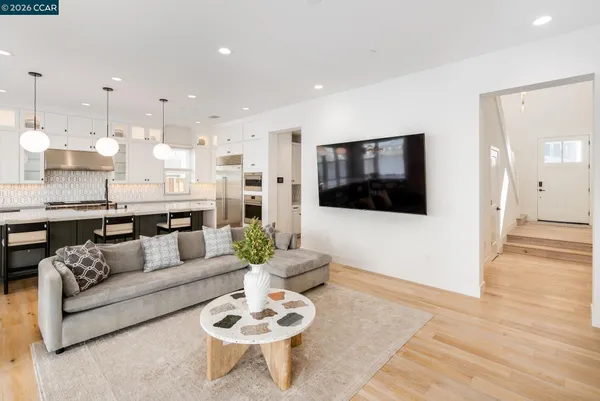a living room with furniture kitchen view and a flat screen tv