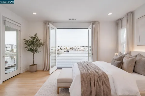 a bedroom with a large bed and a potted plant