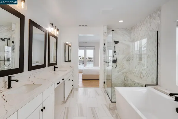 a spacious bathroom with a tub sink shower and mirror