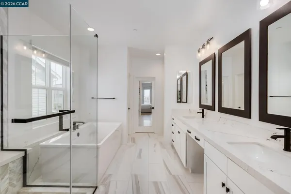 a spacious bathroom with a double vanity sink a large mirror and shower