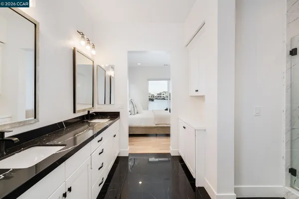 a bathroom with a granite countertop double vanity sink and mirror