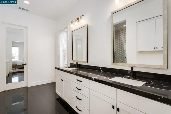 a bathroom with double sink and a mirror