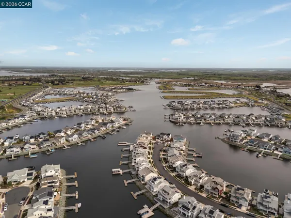 an aerial view of ocean and residential houses with outdoor space