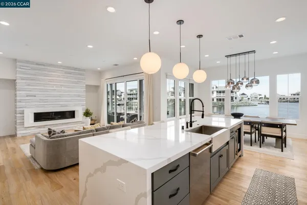 a kitchen with stainless steel appliances a stove a sink a oven a dining table and chairs