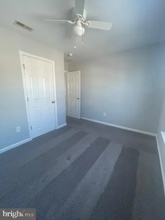 en empty room with windows and fan