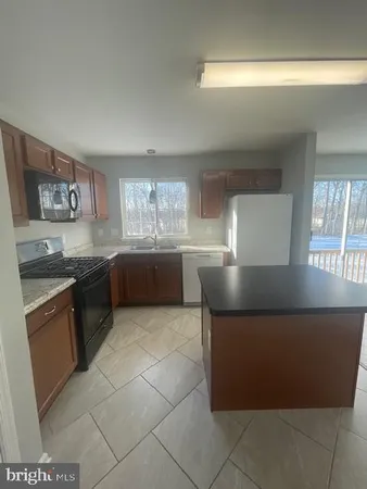 a large kitchen with a stove a sink and a microwave