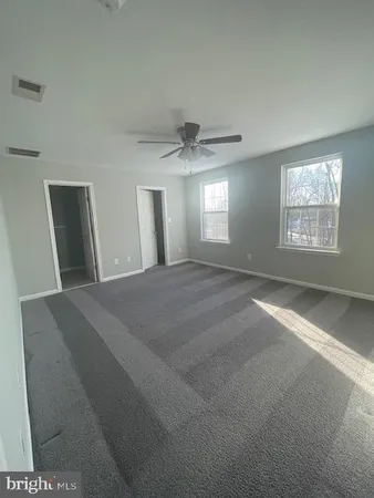 a view of a big room with windows and chandelier fan