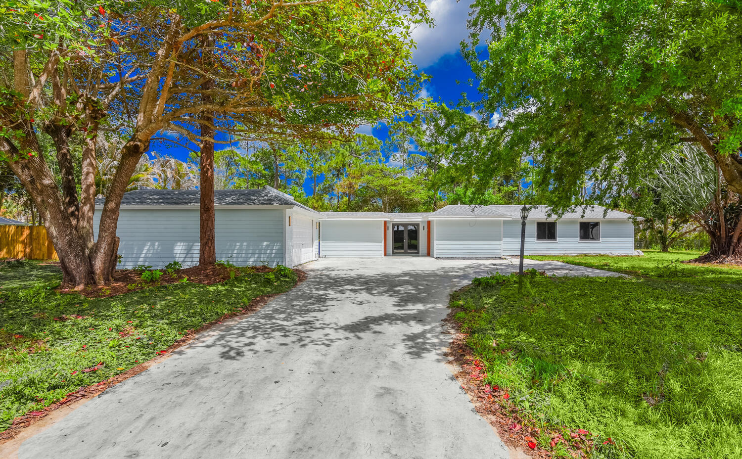 8587 Southwest 18th Avenue Stuart, FL 34997 - Photo 3 of 39 a front view of a house with a garden