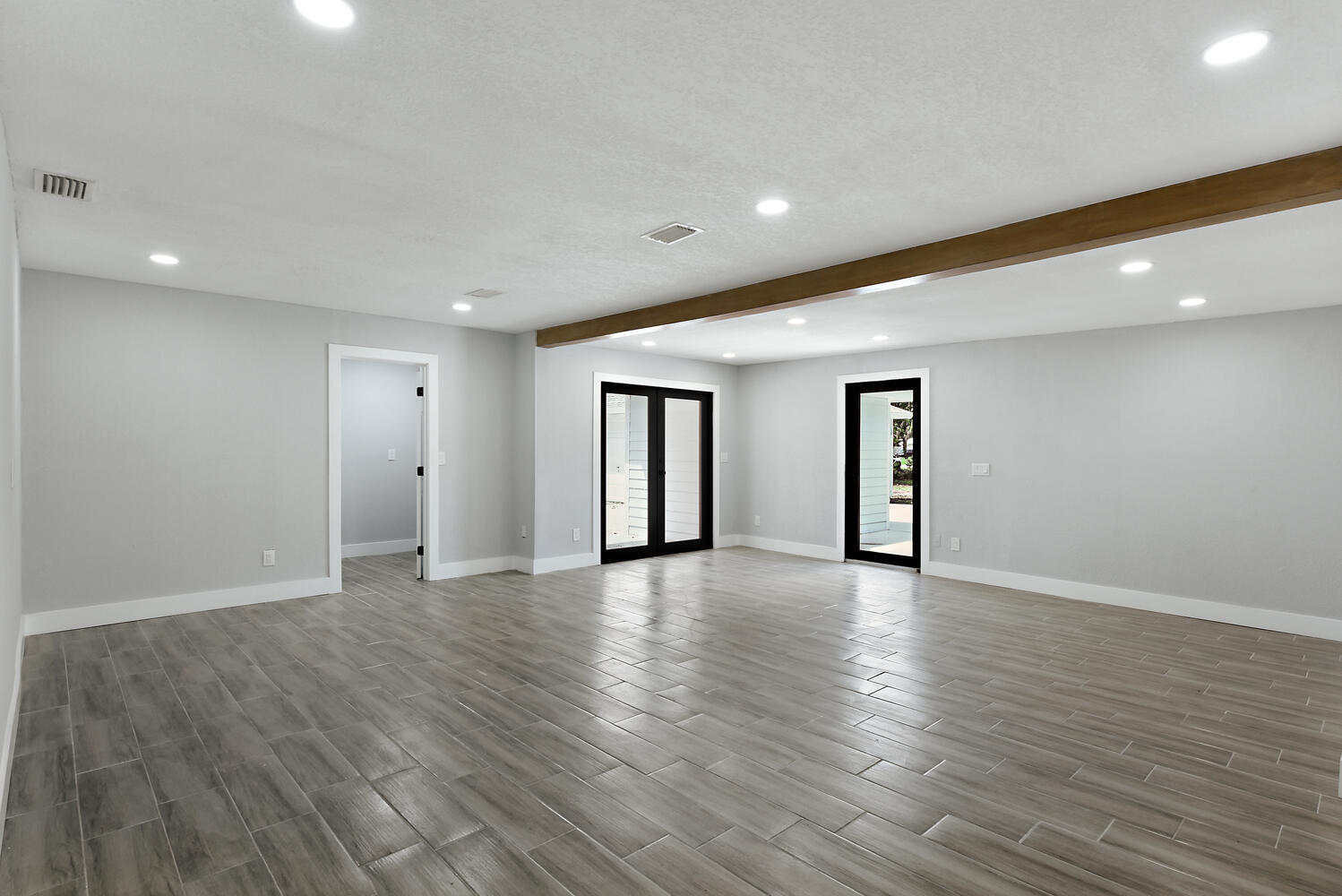 8587 Southwest 18th Avenue Stuart, FL 34997 - Photo 7 of 39 a view of an empty room with wooden floor and window