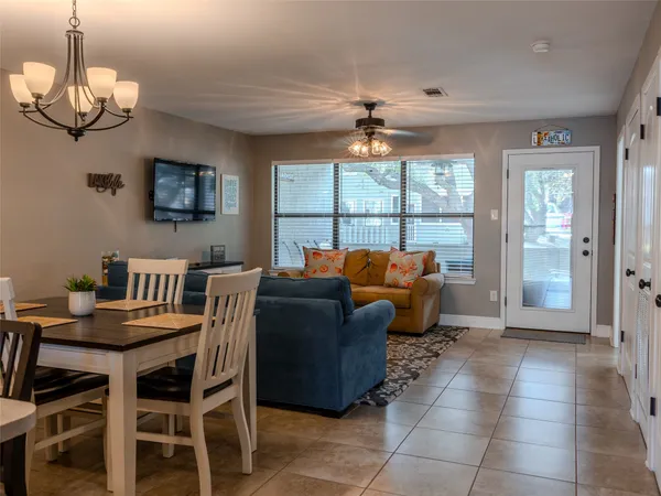 a living room with furniture a chandelier and a dining table