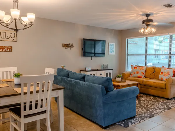 a living room with furniture a chandelier and a flat screen tv