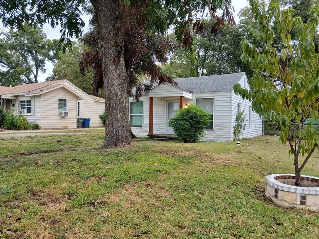a front view of house with yard and trees