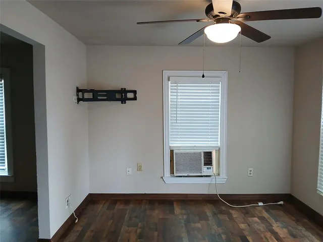 a view of a room with wooden floor and ceiling fan