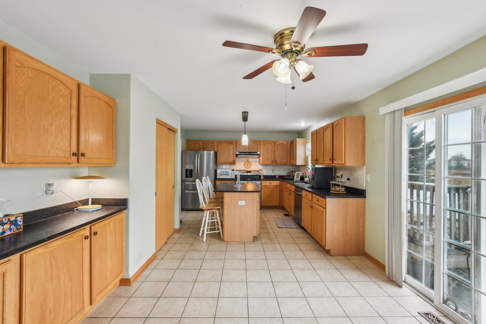 1608 Prairieview Boulevard Bolingbrook, IL 60490 - Photo 14 of 55 a kitchen with a refrigerator a stove top oven a sink a dining table and chairs