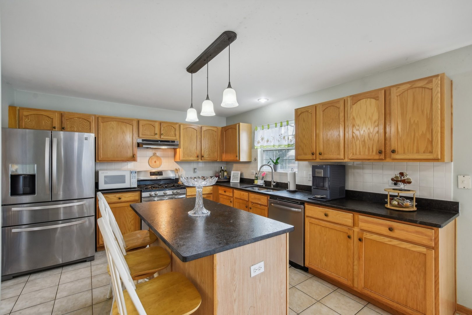 1608 Prairieview Boulevard Bolingbrook, IL 60490 - Photo 15 of 55 a kitchen with kitchen island granite countertop a sink a counter space appliances and cabinets