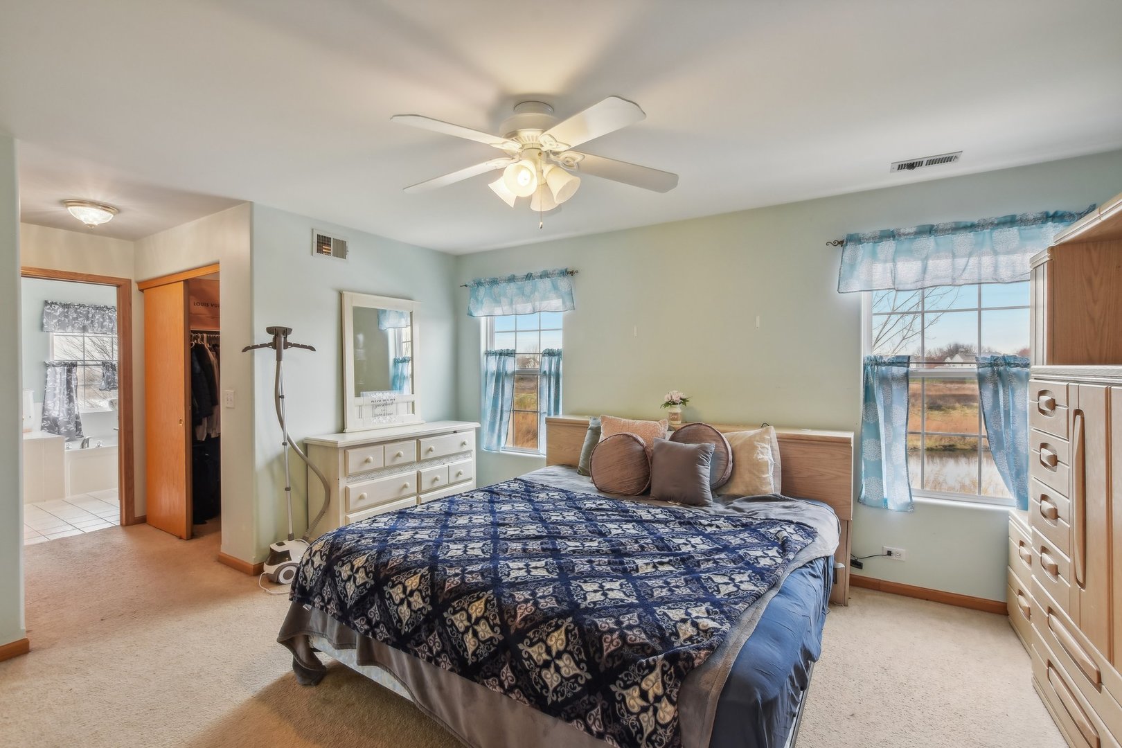 1608 Prairieview Boulevard Bolingbrook, IL 60490 - Photo 24 of 55 a bedroom with a large bed and a chandelier