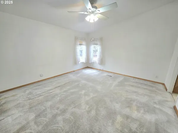an empty room with a chandelier fan
