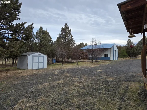 a backyard of a house with a garden and barbeque oven