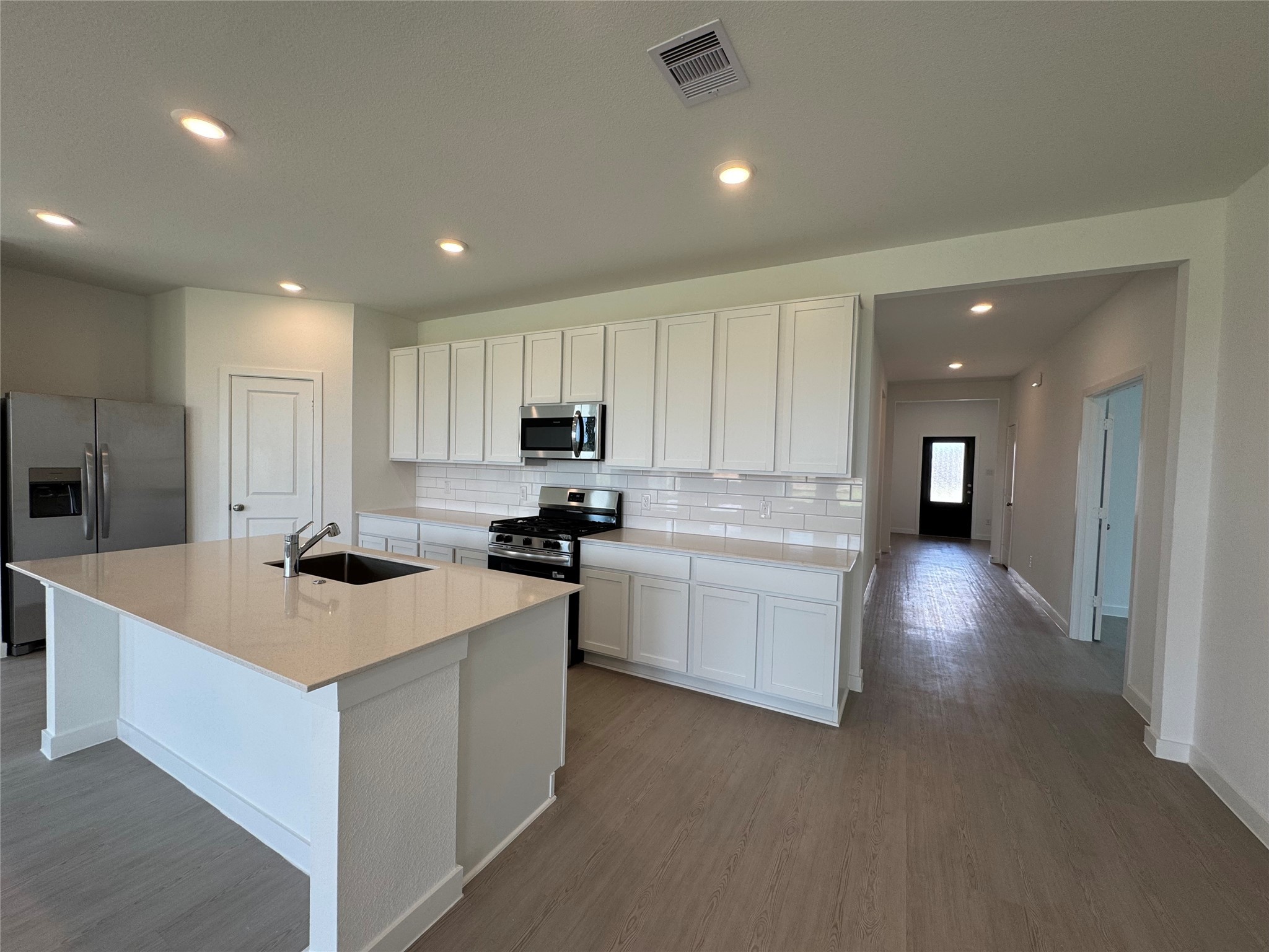 a kitchen with white cabinets and stainless steel appliances