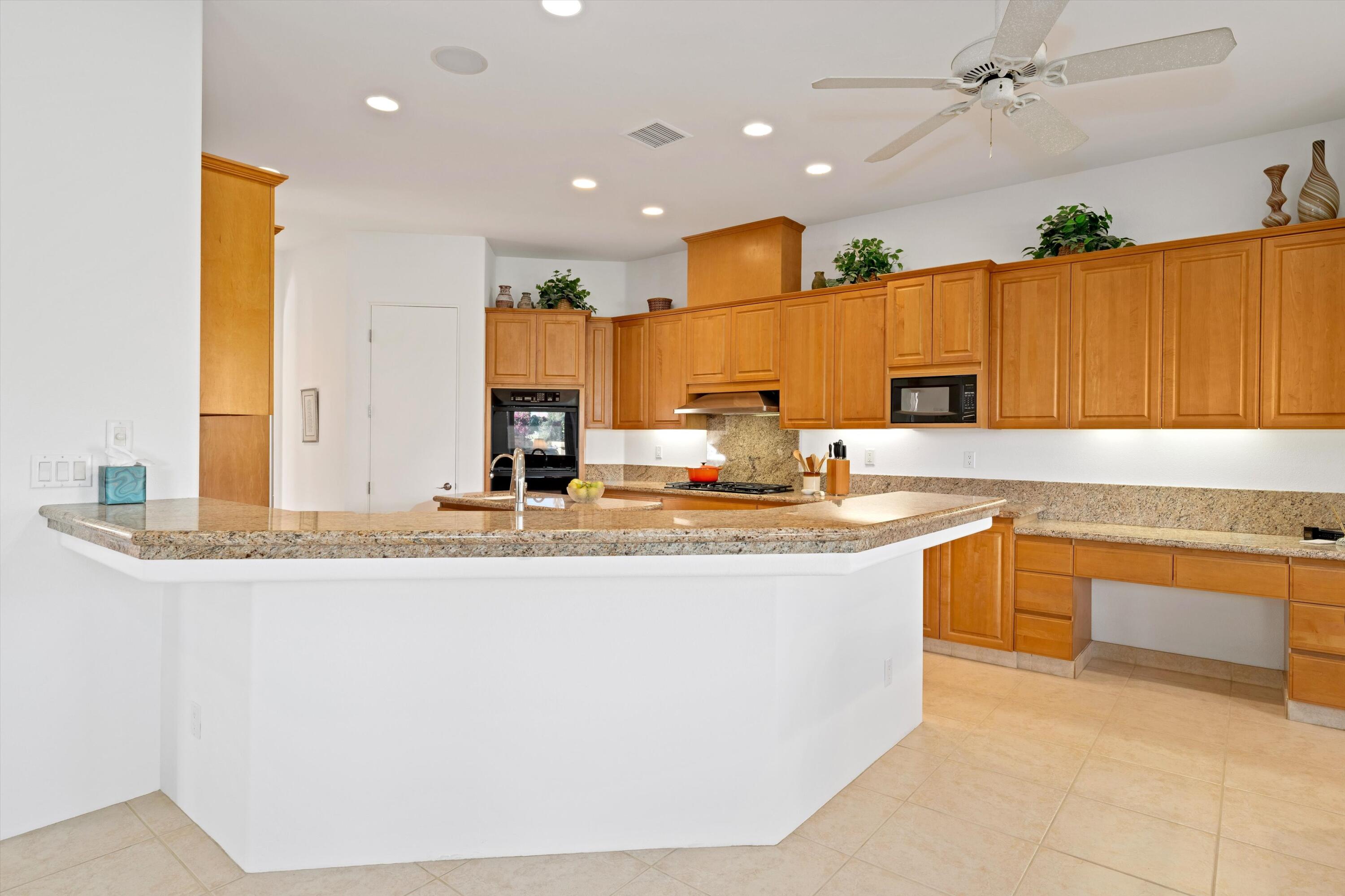 55151 Laurel Valley La Quinta, CA 92253 - Photo 24 of 43 a kitchen with stainless steel appliances granite countertop a sink and a refrigerator