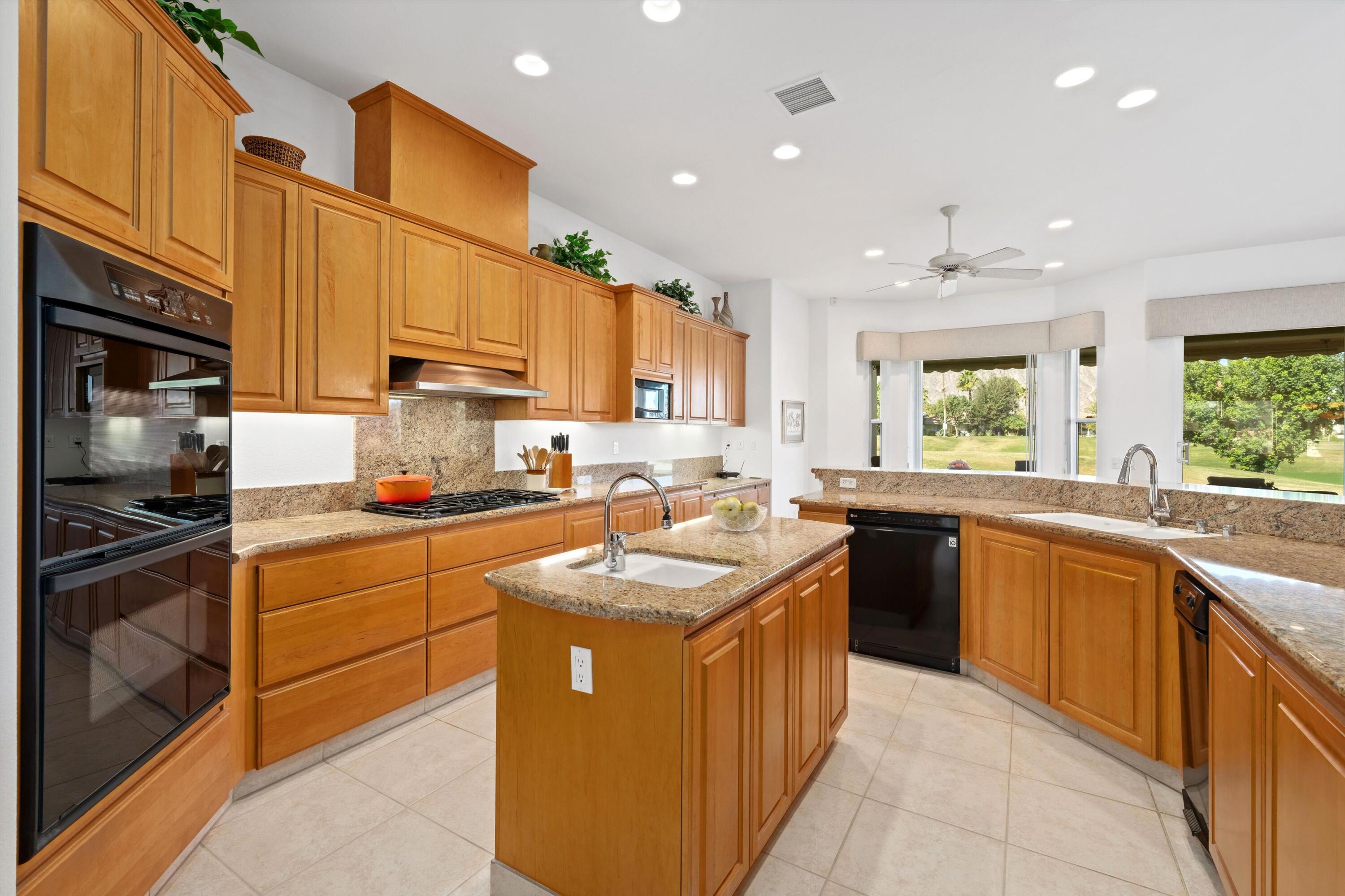 55151 Laurel Valley La Quinta, CA 92253 - Photo 26 of 43 a kitchen with stainless steel appliances granite countertop a sink stove and refrigerator
