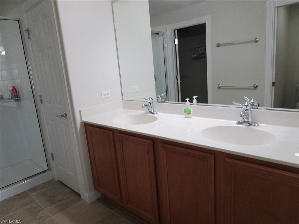 8677 Erice Court Naples, FL 34114 - Photo 11 of 42 a bathroom with a double vanity sink and mirror