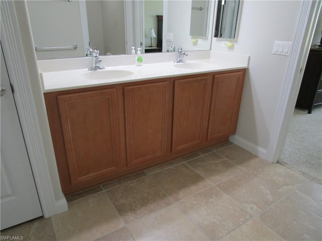 8677 Erice Court Naples, FL 34114 - Photo 13 of 42 a bathroom with a double vanity sink and a mirror