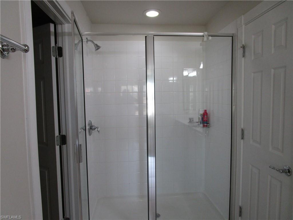 8677 Erice Court Naples, FL 34114 - Photo 14 of 42 a bathroom with a shower and a glass door