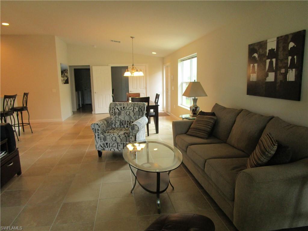 8677 Erice Court Naples, FL 34114 - Photo 27 of 42 a living room with furniture and a chandelier