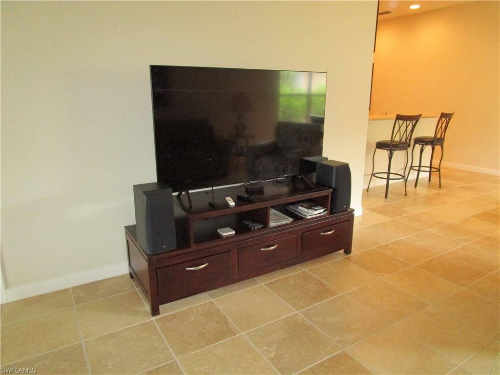 8677 Erice Court Naples, FL 34114 - Photo 28 of 42 a room with furniture and a flat screen tv